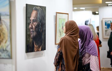 Two women looking at artwork hanging on the wall